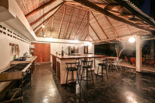 a kitchen with a bar with stools in it at Pipe House Playa Grande in Playa Grande