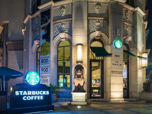 a starbucks coffee building with a sign in front of it at The Davis Bangkok in Bangkok