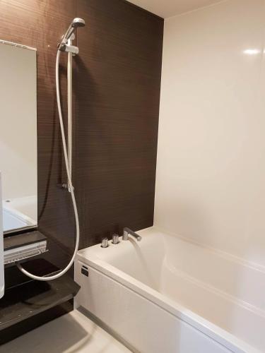 a bathroom with a white tub and a shower at Chill Madarao in Iiyama