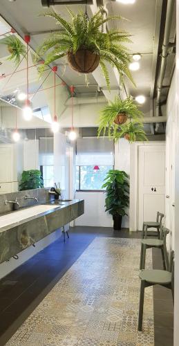 a large kitchen with plants hanging from the ceilings at The Pod at Beach Road Boutique Capsule Hotel in Singapore