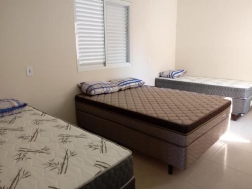 a bedroom with two beds and a window at Costa do Encanto unidade Itapoa in Itapoa