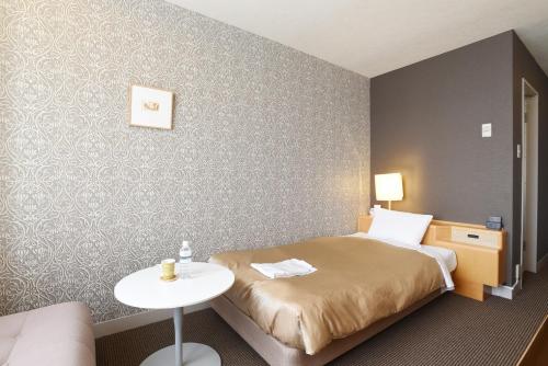 a hotel room with a bed and a table at Hotel Grand Vert Gizan in Gifu