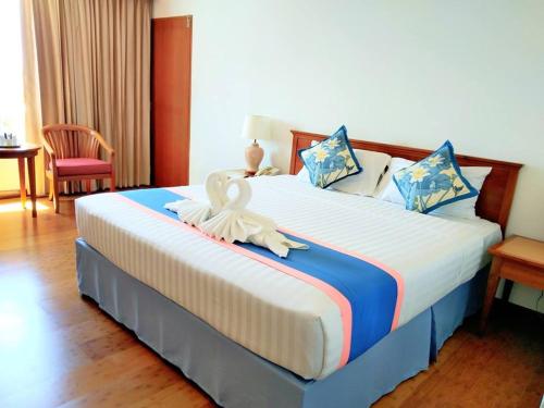 a bedroom with a large bed in a room at Diamond Plaza Hotel in Surat Thani