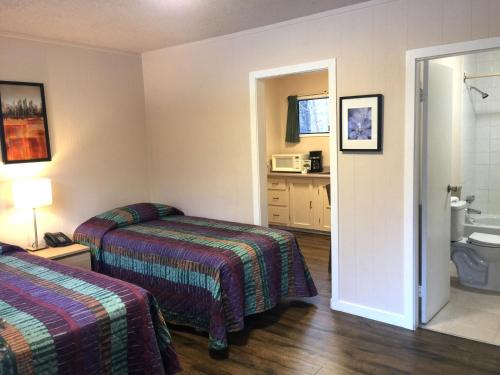 a hotel room with two beds and a bathroom at The Hitching Post Motel in Pemberton