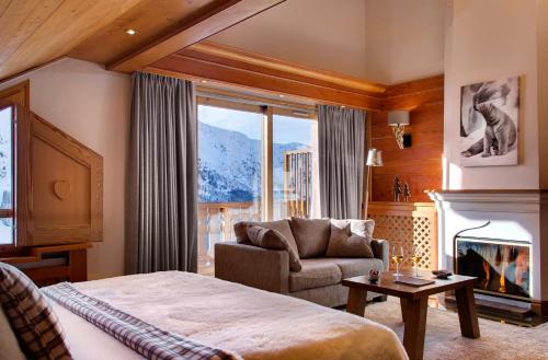 a hotel room with a bed and a fireplace at Hotel Allodis in Méribel