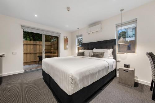 um quarto com uma cama grande e uma varanda em Melbourne Airport Motel em Melbourne