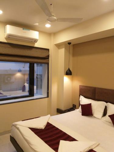 a bedroom with a bed and a window with a air conditioner at The Fountain Inn - Fort in Mumbai
