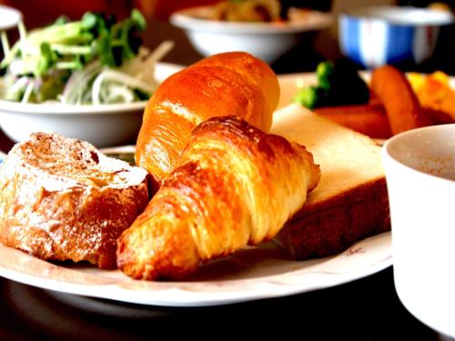 a plate of food with croissants and bread on a table at APA Hotel Sagaeki Minamiguchi in Saga