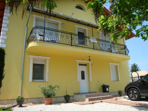 a yellow house with a balcony on it at Yellow Apartmanház in Bük