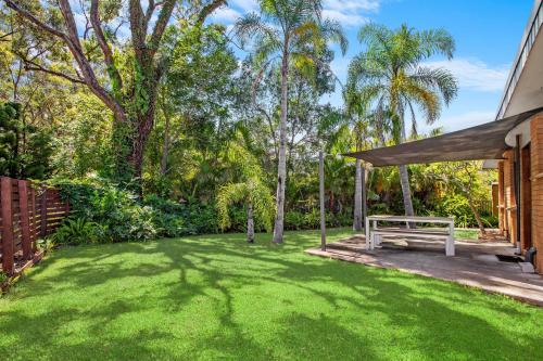 a backyard with a bench and a grass yard at NRMA South West Rocks Holiday Park in South West Rocks