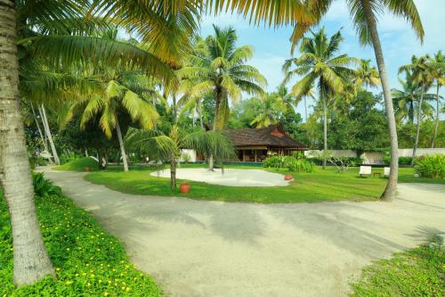 a path in front of a resort with palm trees at Vismaya by Moksha Stays in Turavūr