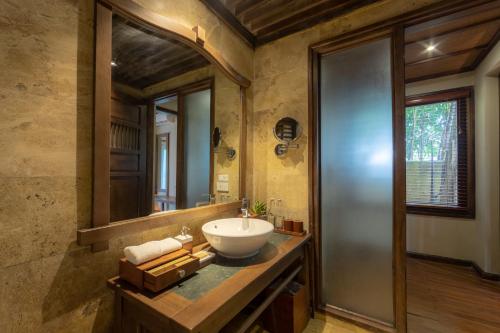 a bathroom with a sink and a mirror at Melia Ba Vi Mountain Retreat in Hanoi