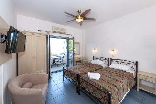 a bedroom with a bed and a tv and a chair at Lakonia studios in Stoupa