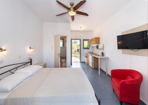 a bedroom with a bed and a red chair at Lakonia studios in Stoupa