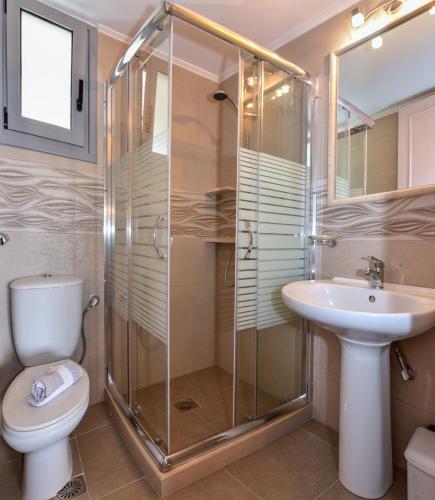 a bathroom with a shower and a toilet and a sink at Lakonia studios in Stoupa