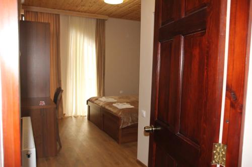 a room with a bedroom with a bed and a door at Hotel Patriot in Mestia