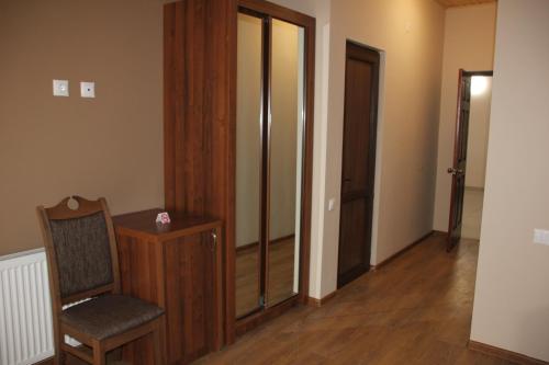 a room with a chair and a glass door at Hotel Patriot in Mestia