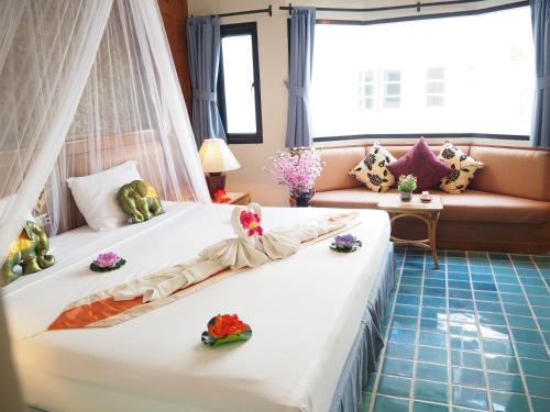 a bedroom with two beds and a couch at Your Place Inn in Karon Beach