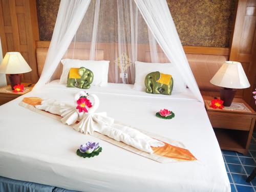 a bedroom with a bed with flowers on it at Your Place Inn in Karon Beach