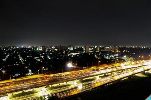 a city at night with traffic on a freeway at Well Designed 2BR Green Pramuka City Apartment By Travelio in Jakarta