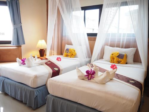 a hotel room with three beds with stuffed animals on them at Your Place Inn in Karon Beach