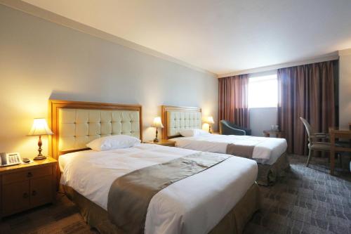 Postel nebo postele na pokoji v ubytování Daegu AW Hotel