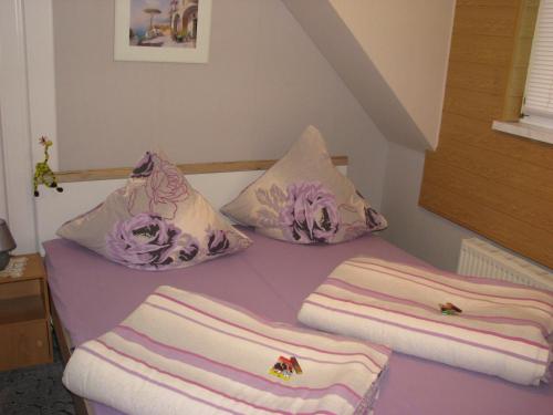 a bed with pillows on it with a purple table at Ferienwohnung Klement in Neubukow