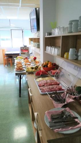 un mostrador de cocina con muchos platos de comida. en Hotel Don Pelayo, en L'Arboç