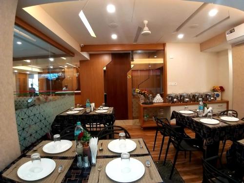 a dining room with tables and chairs in a restaurant at GRAND ELEGANT in Chennai