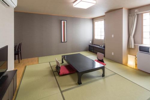a large living room with a table and chairs at Hotel Mystays Nayoro in Nayoro