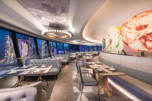成都Chengdu Taikoo Li Chunxi Mercure Hotel的一间有桌椅、可以欣赏城市景观的餐厅