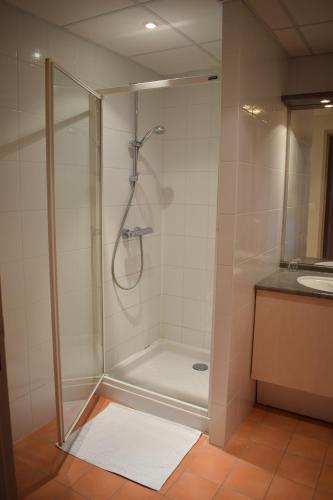 a shower with a glass door in a bathroom at Azureva Métabief in Métabief