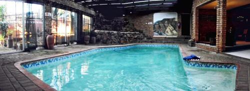 a large swimming pool in a building with at Autumn Breeze Manor Guest House in Graskop