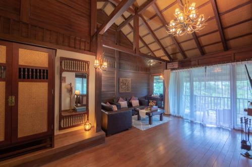 a living room with wooden walls and a chandelier at Melia Ba Vi Mountain Retreat in Hanoi