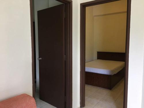 um pequeno quarto com uma cama e um espelho em Homestay Suria Bukit Merah em Simpang Ampat Semanggol