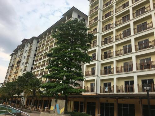 um grande edifício com uma árvore em frente em Homestay Suria Bukit Merah em Simpang Ampat Semanggol