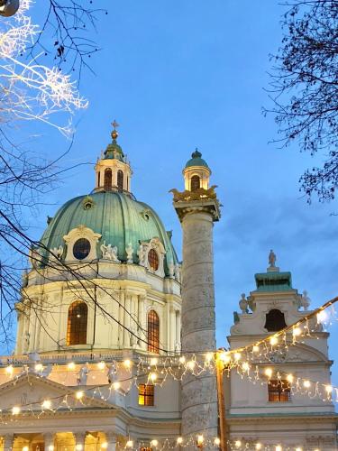 a building with a dome and a tower with lights at Best Place Apartments Vienna in Vienna