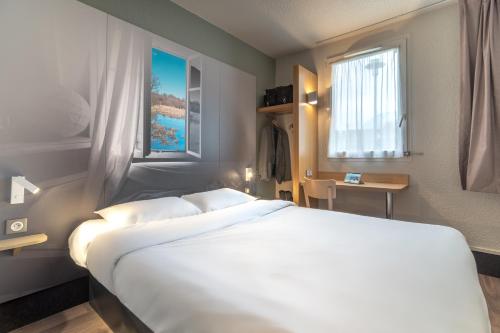 Tempat tidur dalam kamar di B&B HOTEL CHATEAUROUX Déols