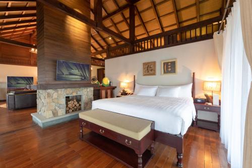 a bedroom with a large bed and a fireplace at Melia Ba Vi Mountain Retreat in Hanoi