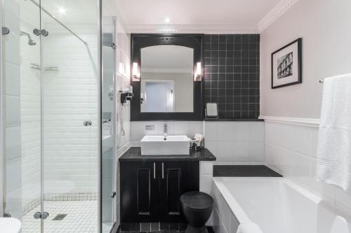 a bathroom with a sink and a tub and a shower at Romney Park Luxury Apartments by The Stay Collection in Cape Town