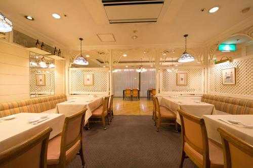 a dining room with white tables and chairs at Tottori Washington Hotel Plaza in Tottori