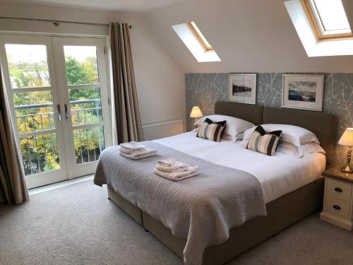 a bedroom with a large bed with towels on it at Riverbank Apartments in Nairn