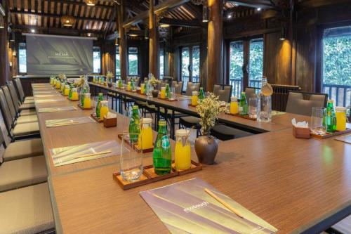a long table with glasses and bottles on it at Melia Ba Vi Mountain Retreat in Hanoi