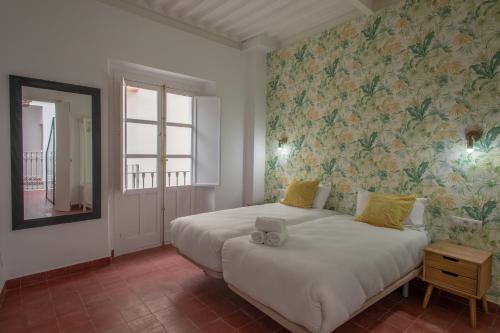 sypialnia z dużym białym łóżkiem i oknem w obiekcie Casas de Sevilla - Casa Sevillana Harinas26 w Sewilli
