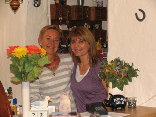 two women standing next to a counter with flowers at Hotel Talburg in Heiligenhaus