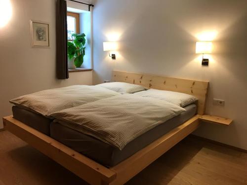 a bed with a wooden frame in a bedroom at Haus Ramsauer in Werfenweng