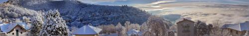 a snow covered mountain with a town in the foreground at Locanda Milano 1873 in Brunate