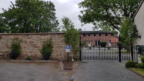 a gate in front of a building with a house at Zimmervermietung BredyGbR in Querfurt