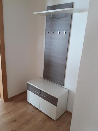 a closet with a white cabinet and a mirror at Barschtlerhof in Axams