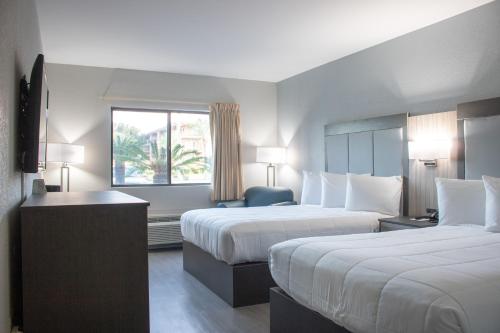 ein Hotelzimmer mit 2 Betten und einem Fenster in der Unterkunft Admiral's Inn on Tybee Island in Tybee Island